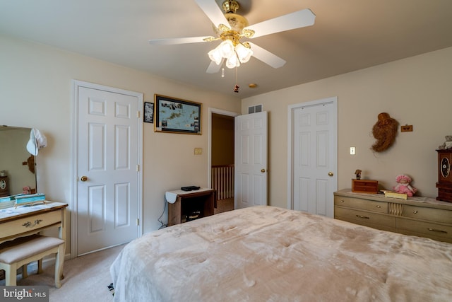 bedroom with ceiling fan and light carpet