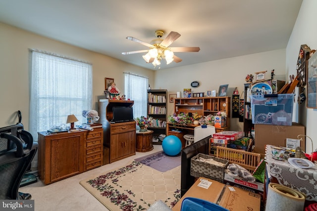 carpeted office space featuring ceiling fan