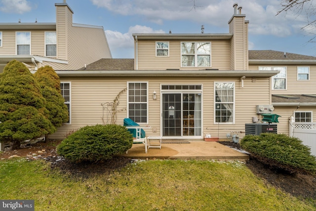 rear view of house featuring central AC unit, a yard, and a patio area