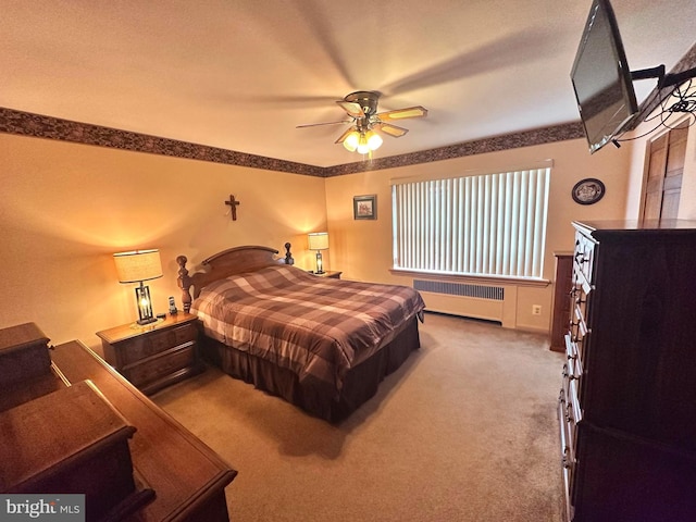 carpeted bedroom featuring radiator heating unit and ceiling fan