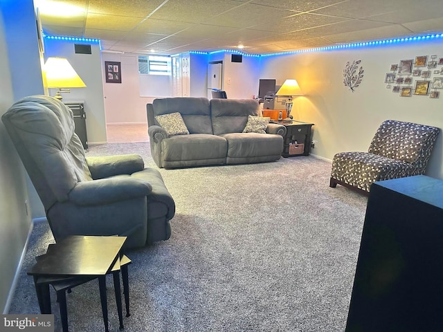 carpeted living room with a paneled ceiling