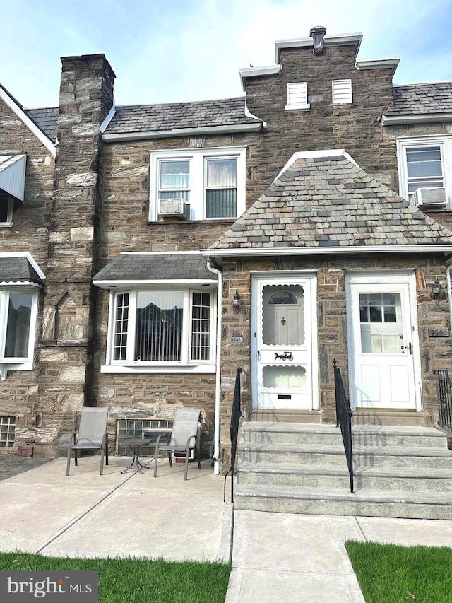 view of front of house with cooling unit and a patio area