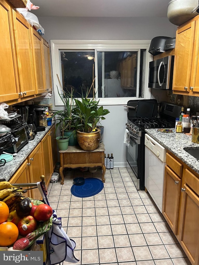 kitchen featuring light stone counters, light tile patterned floors, black gas stove, dishwasher, and decorative backsplash