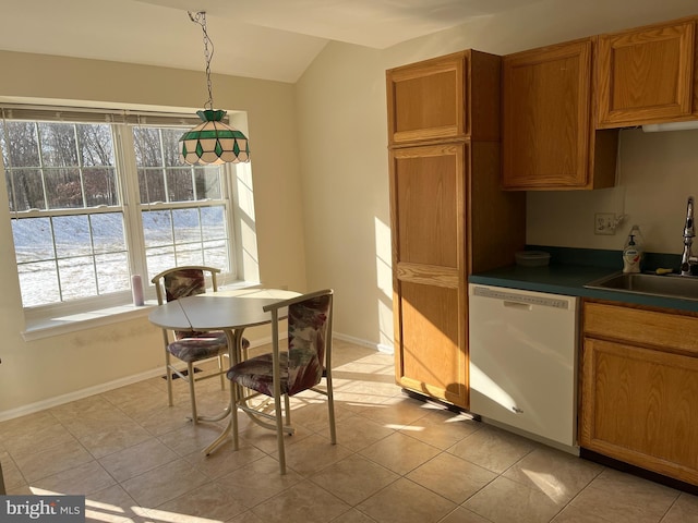 kitchen featuring decorative light fixtures, lofted ceiling, sink, light tile patterned floors, and white dishwasher