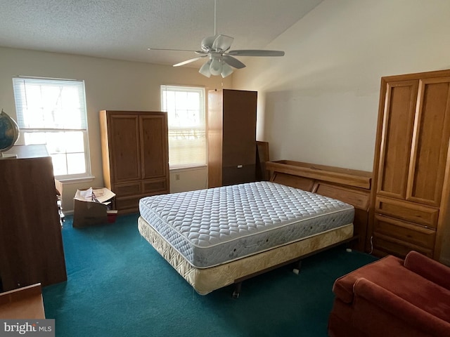 carpeted bedroom featuring ceiling fan, lofted ceiling, and a textured ceiling