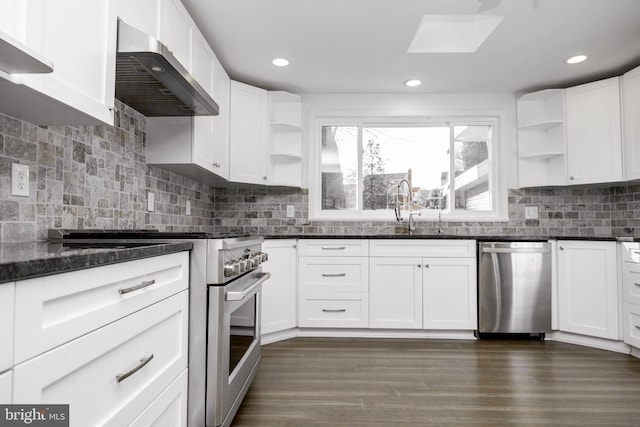 kitchen featuring stainless steel appliances, white cabinets, wall chimney exhaust hood, and open shelves