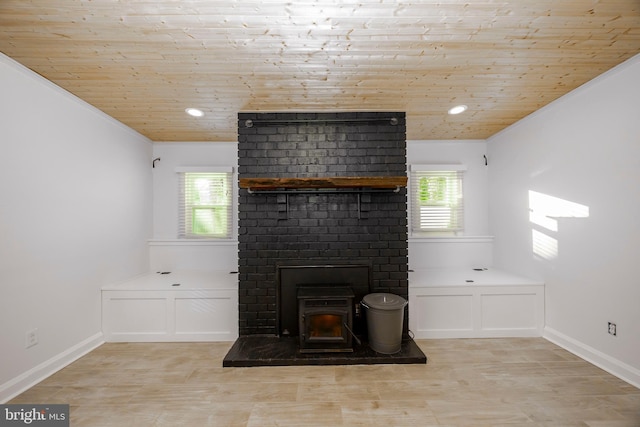 unfurnished living room with wood ceiling, a healthy amount of sunlight, and baseboards