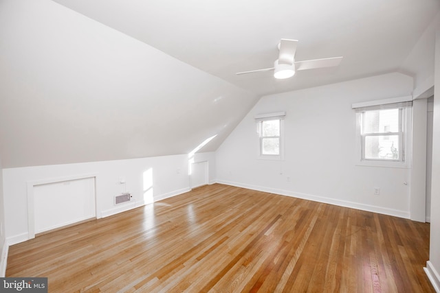 bonus room featuring lofted ceiling, hardwood / wood-style flooring, visible vents, and a ceiling fan