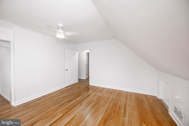 bonus room with light wood-type flooring, vaulted ceiling, baseboards, and ceiling fan