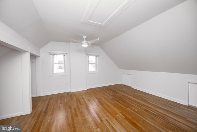 bonus room featuring attic access, baseboards, vaulted ceiling, and hardwood / wood-style floors