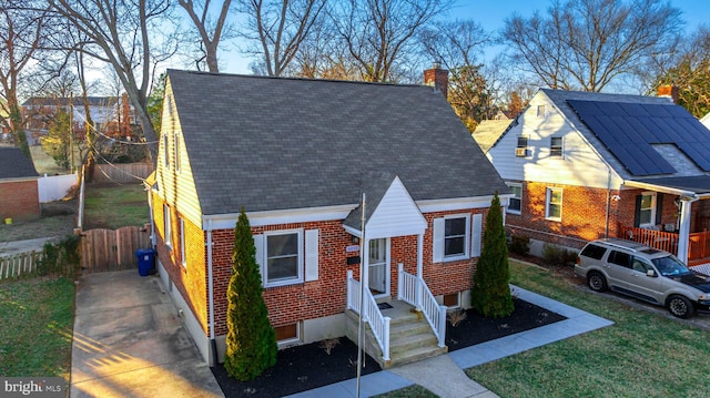 view of front of home featuring a chimney, fence, and brick siding