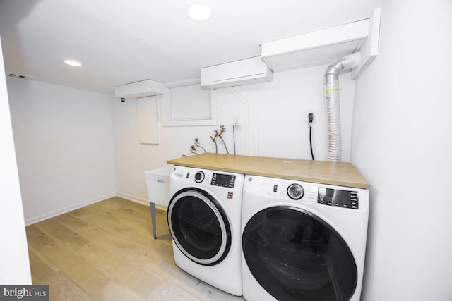 clothes washing area featuring recessed lighting, laundry area, baseboards, light wood-type flooring, and independent washer and dryer