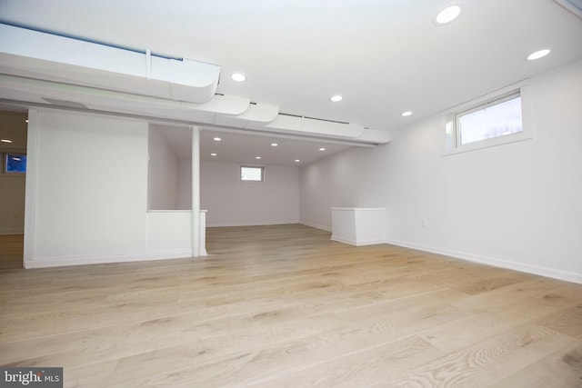 below grade area with light wood-style floors, recessed lighting, and baseboards