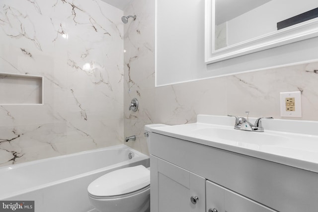 full bathroom featuring tiled shower / bath, vanity, toilet, and tile walls