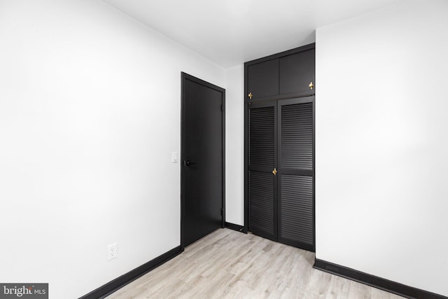 unfurnished bedroom featuring light hardwood / wood-style flooring and a closet