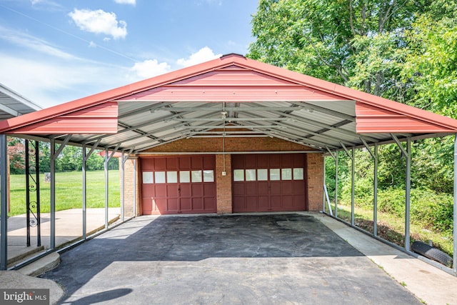 garage featuring a carport and a lawn