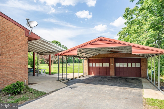 garage featuring a carport and a lawn