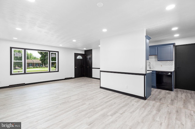 unfurnished living room featuring sink and light hardwood / wood-style flooring