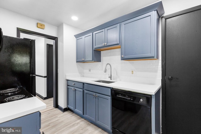 kitchen with blue cabinets, sink, tasteful backsplash, light wood-type flooring, and black appliances