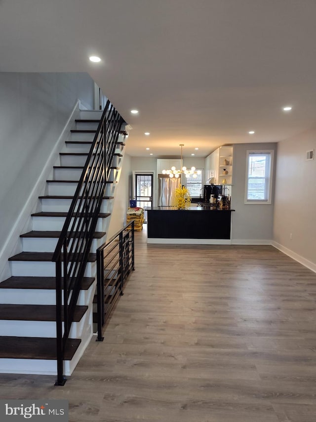 interior space with hardwood / wood-style flooring, a wealth of natural light, and a chandelier