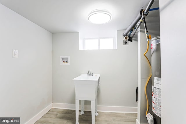 laundry room featuring washer hookup and light hardwood / wood-style flooring