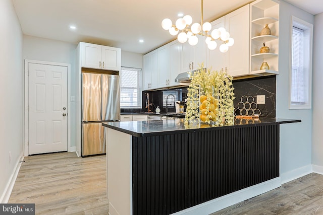 kitchen with stainless steel fridge, light hardwood / wood-style floors, kitchen peninsula, and white cabinets