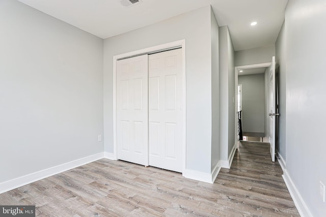 unfurnished bedroom featuring light hardwood / wood-style floors and a closet