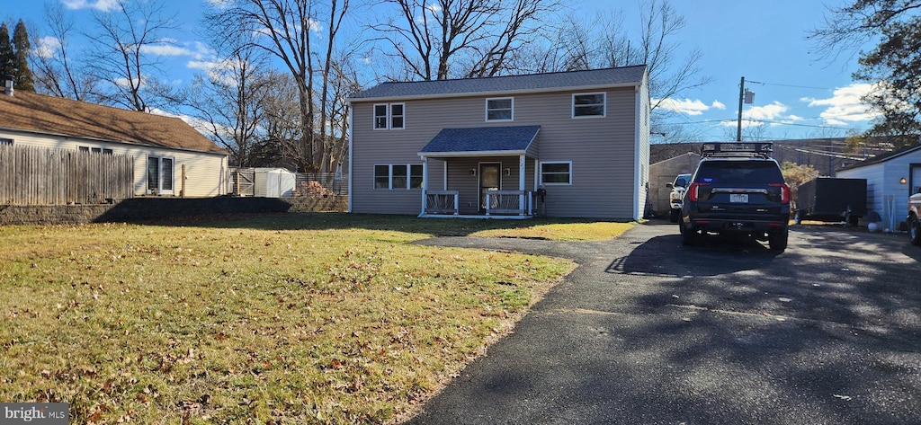 view of property with a porch and a front lawn