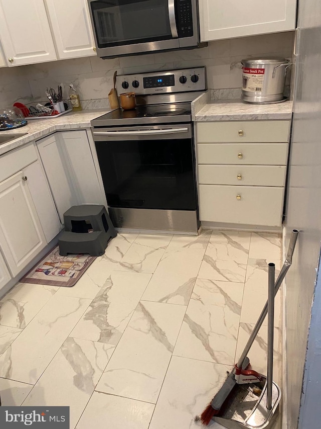 kitchen with white cabinetry, appliances with stainless steel finishes, and backsplash