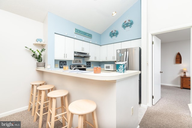 kitchen with a breakfast bar area, white cabinetry, light carpet, kitchen peninsula, and stainless steel appliances