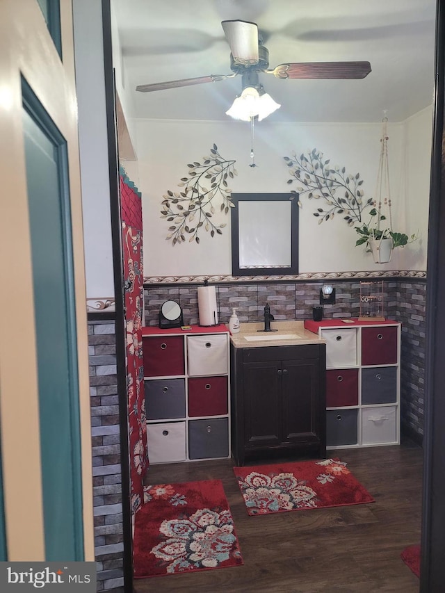 bathroom with vanity, hardwood / wood-style flooring, tile walls, and ceiling fan