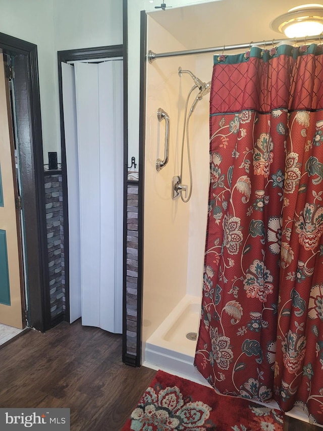 bathroom with hardwood / wood-style flooring and curtained shower