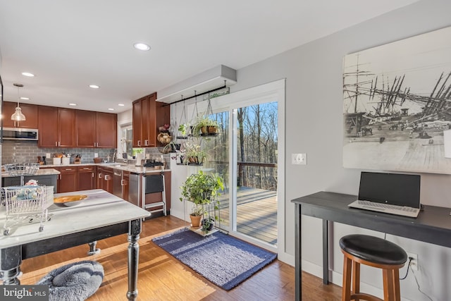 kitchen featuring backsplash, decorative light fixtures, and hardwood / wood-style floors