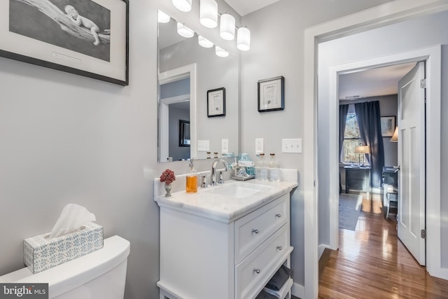 bathroom featuring vanity, wood-type flooring, and toilet