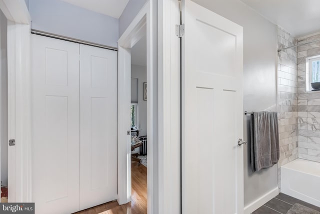 bathroom with tiled shower / bath combo and hardwood / wood-style flooring