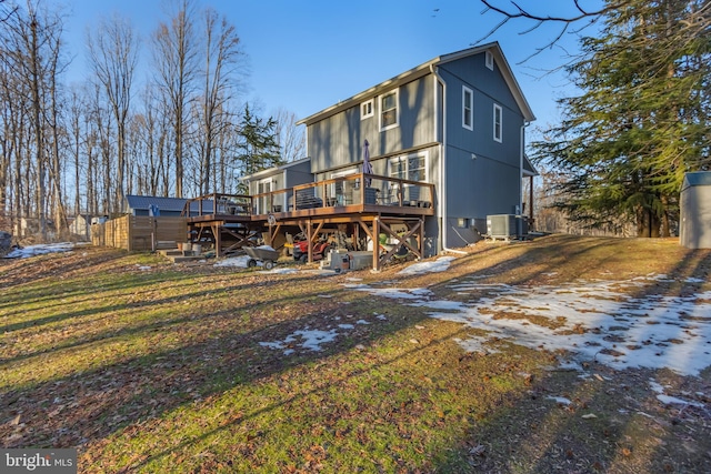 back of property featuring a wooden deck and a yard