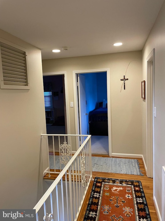 corridor with hardwood / wood-style flooring