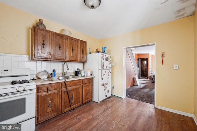 kitchen featuring sink, dark wood-type flooring, backsplash, and white appliances