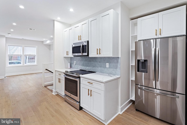 kitchen featuring white cabinetry, appliances with stainless steel finishes, and light stone counters