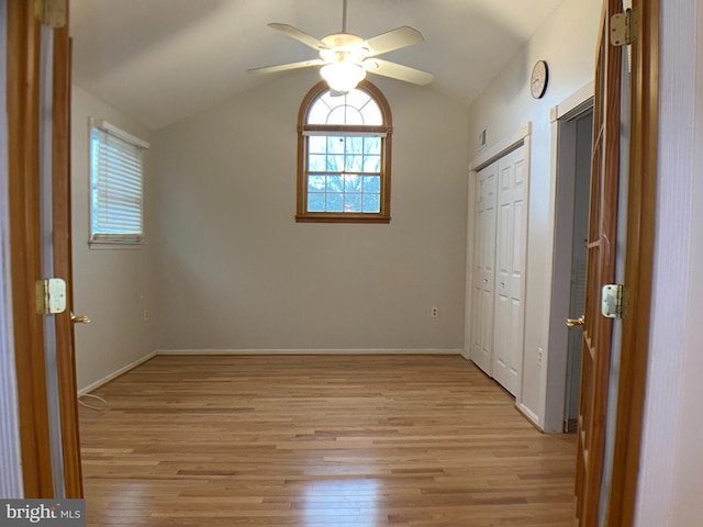 unfurnished bedroom with ceiling fan, lofted ceiling, and light hardwood / wood-style floors