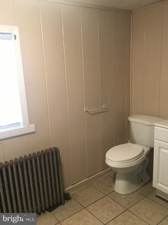 bathroom featuring vanity, radiator, tile patterned floors, and toilet