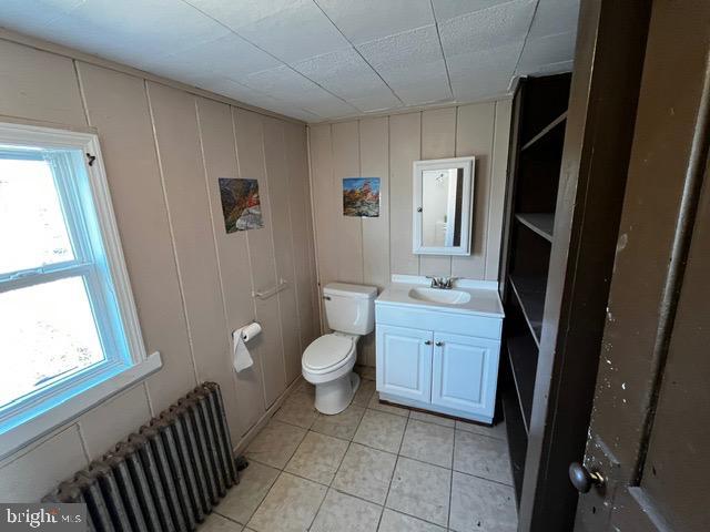 bathroom featuring vanity, radiator heating unit, tile patterned floors, and toilet