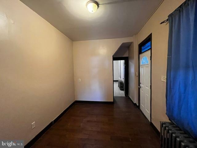 hall with radiator heating unit and dark hardwood / wood-style floors