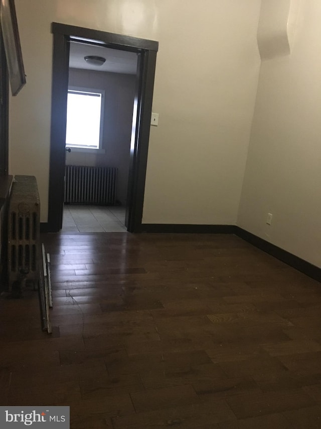 interior space featuring dark wood-type flooring and radiator heating unit