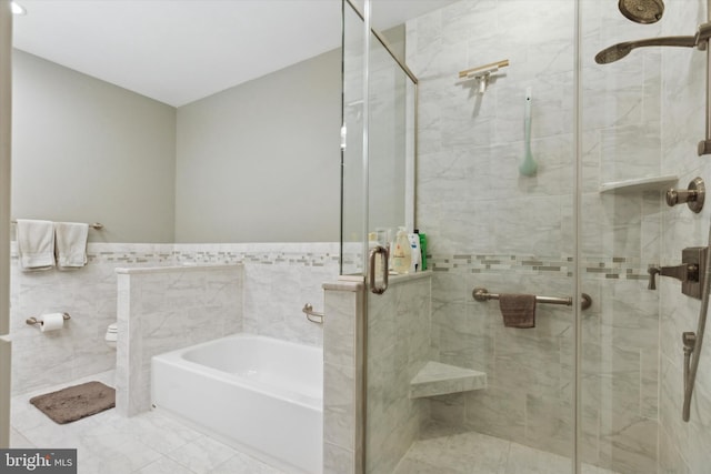 bathroom featuring independent shower and bath and tile walls