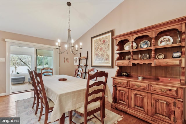 dining room with an inviting chandelier, lofted ceiling, and light hardwood / wood-style floors