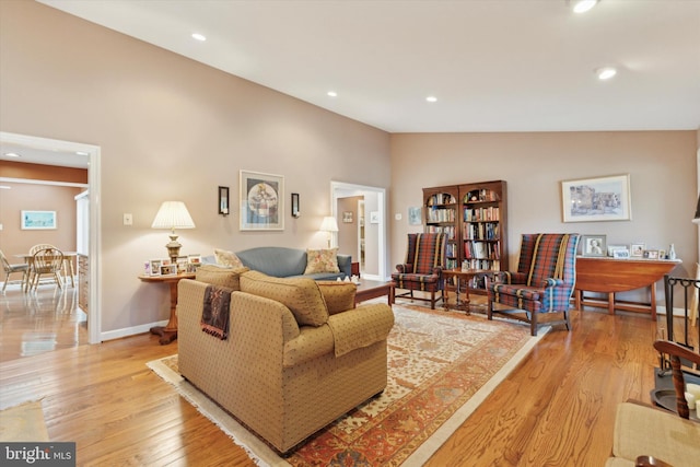 living room featuring vaulted ceiling and light wood-type flooring