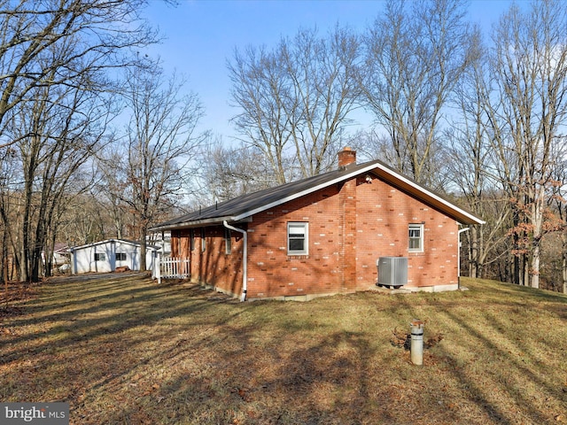 view of property exterior with central AC and a yard