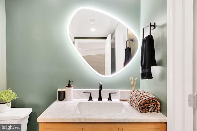 bathroom featuring toilet, visible vents, and vanity