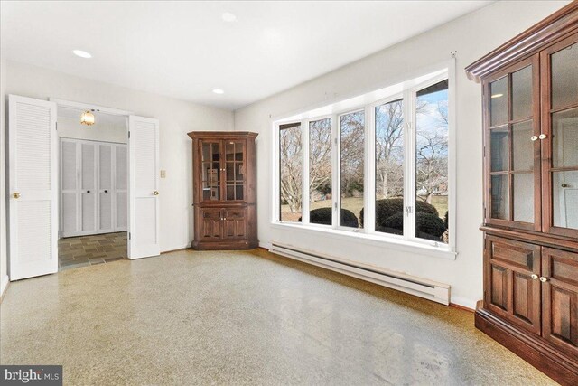 unfurnished room with speckled floor, baseboard heating, and recessed lighting